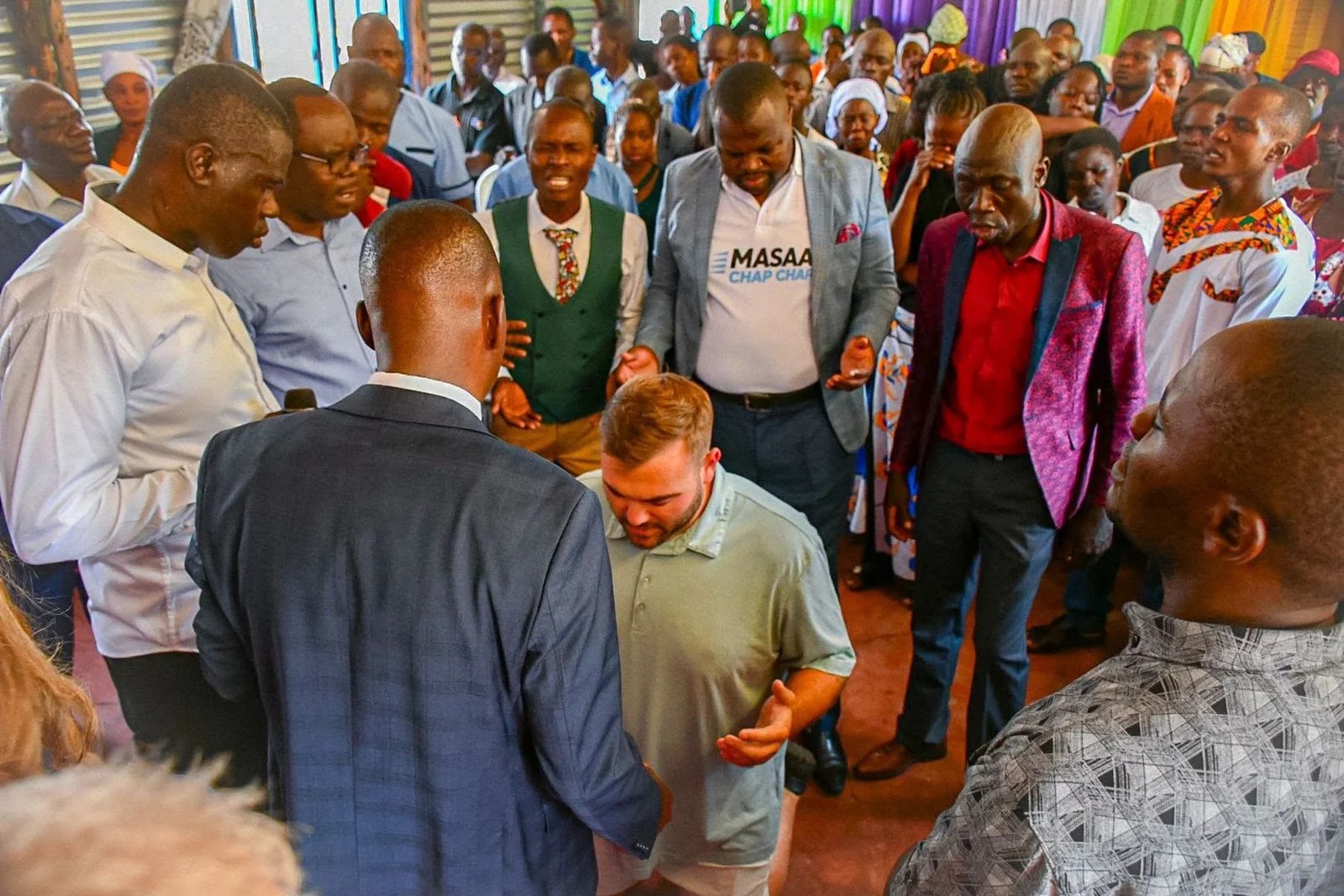 Kenyan pastors praying with Trevor during a visit with Manna Ministries
